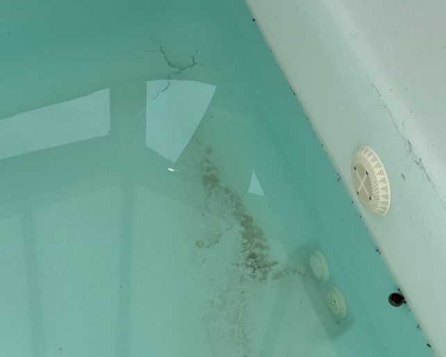 Fissure structurelle dans l'angle d'une piscine coque avec bonde de fond et bouchon d'équilibrage