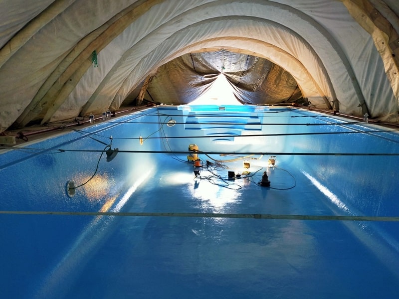 Piscine coque rénovée par application de nouvelles couche de polyester et fibre de verre