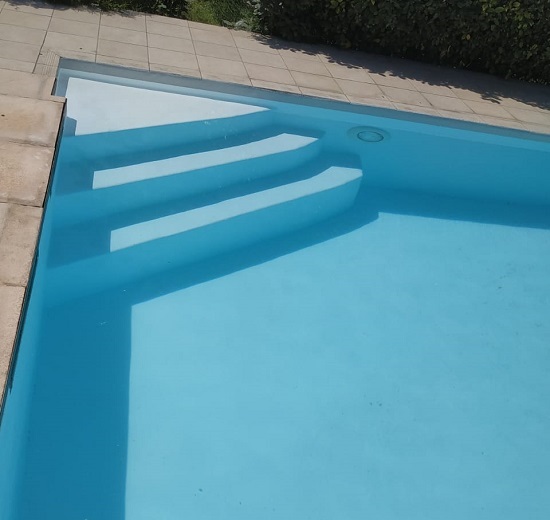 Piscine avec revêtement stratifié en résine polyester et fibre de verre en eau