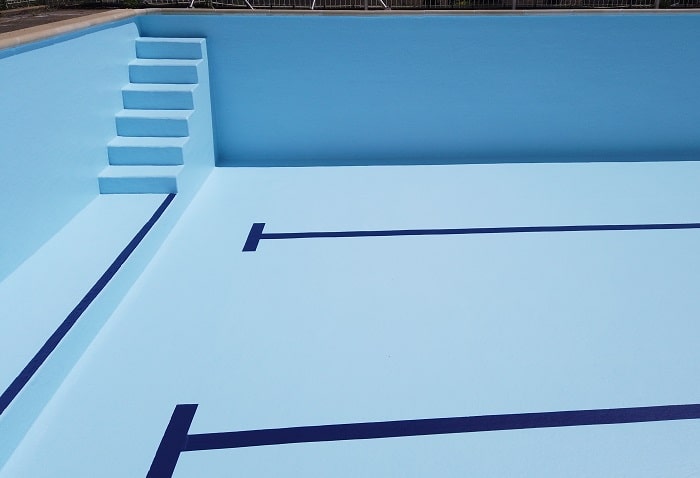 revêtement piscine en résine bleu clair avec lignes de nage